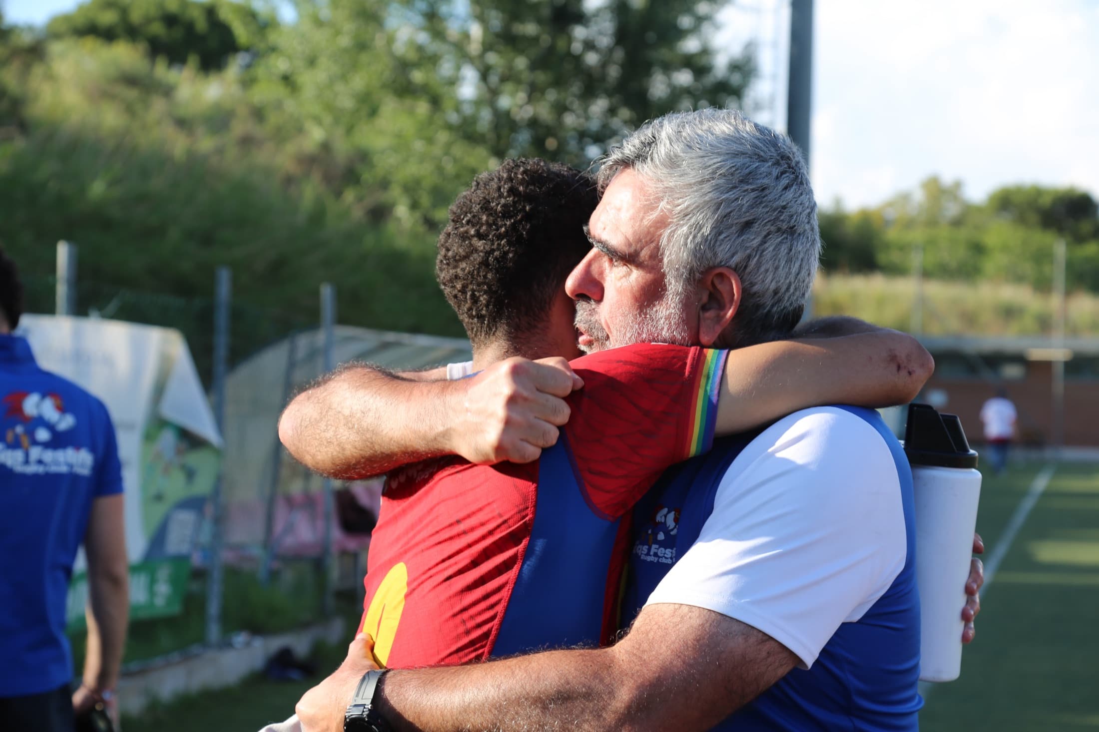 Un joueur des Coqs Festifs enlacé par son coach après un match